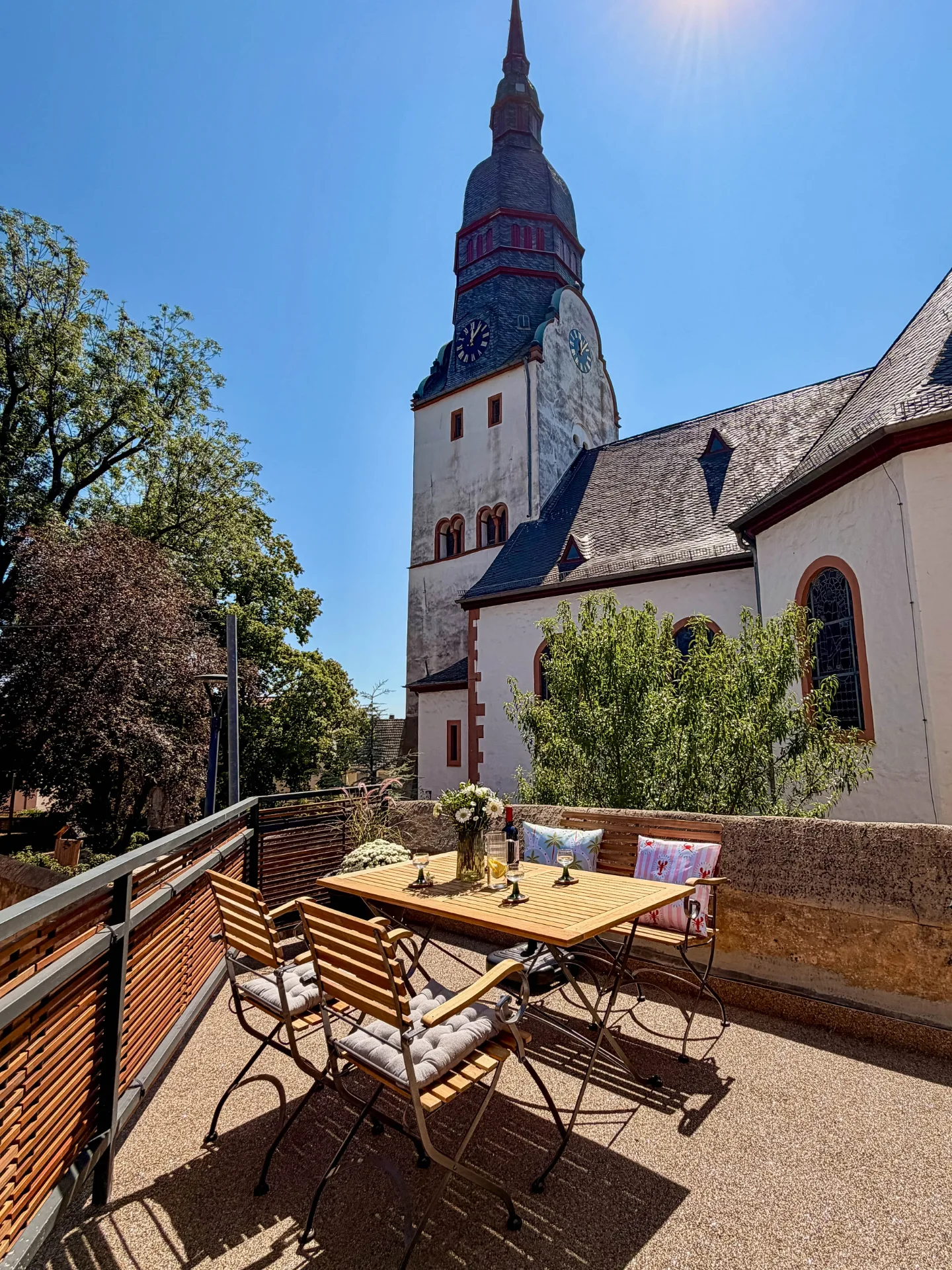 Möblierter Balkon des Markt Quartiers in Nierstein mit direktem Blick auf die historische Kirche.