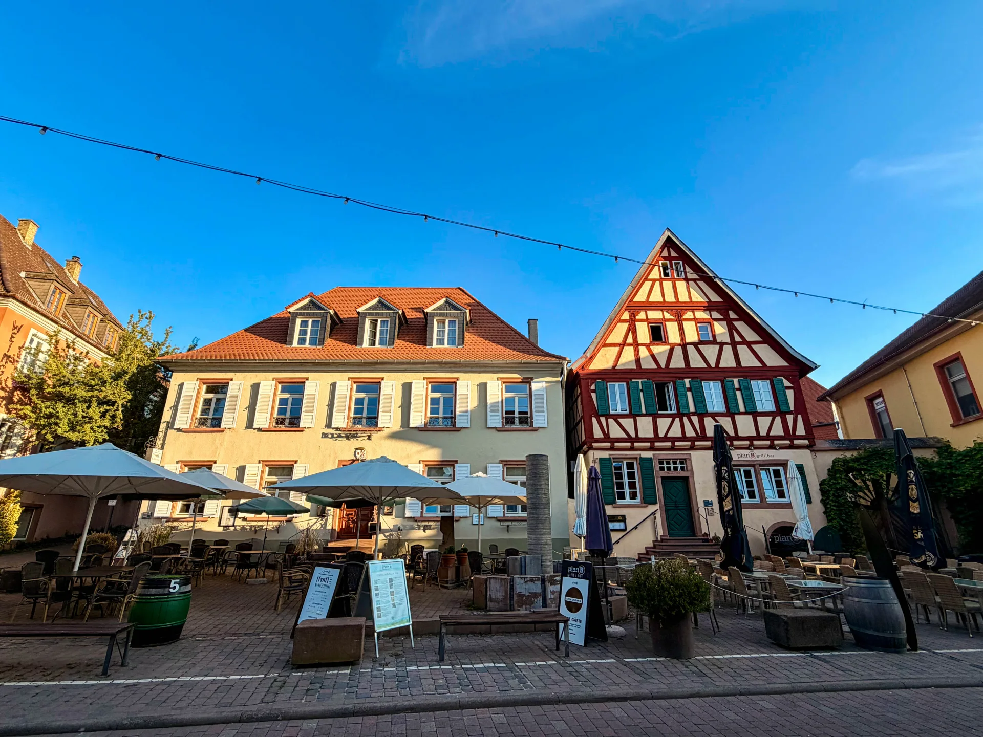 Historischer Marktplatz von Nierstein mit Fachwerkhaus, Außengastronomie und traditionellen Altstadthäusern.