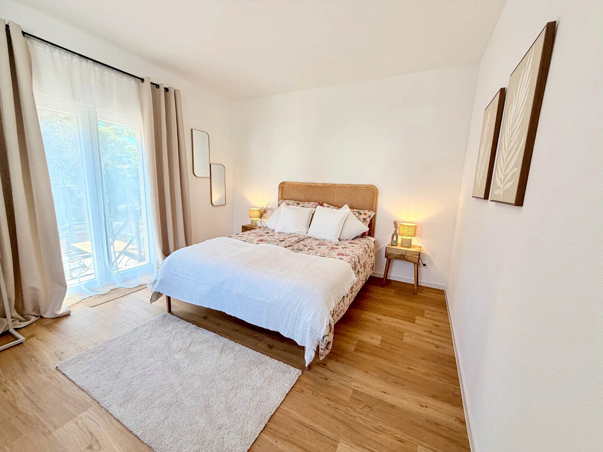 Helles Schlafzimmer des Markt Quartiers in Nierstein mit Doppelbett, Holzboden und Zugang zum Balkon.